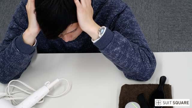 頭を抱えて悩んでいる様子の男性